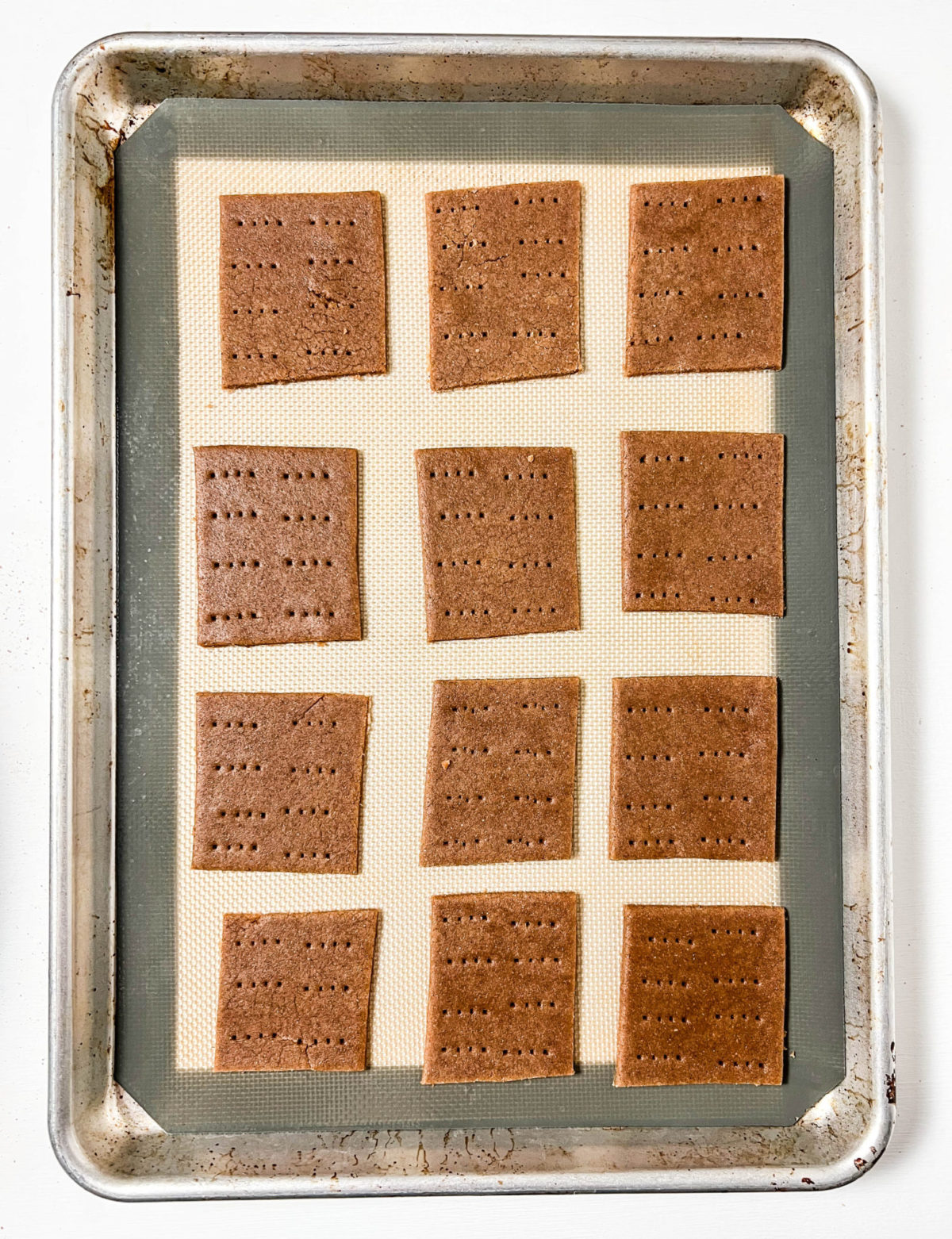Overhead shot of graham crackers on a baking sheet before baking. 