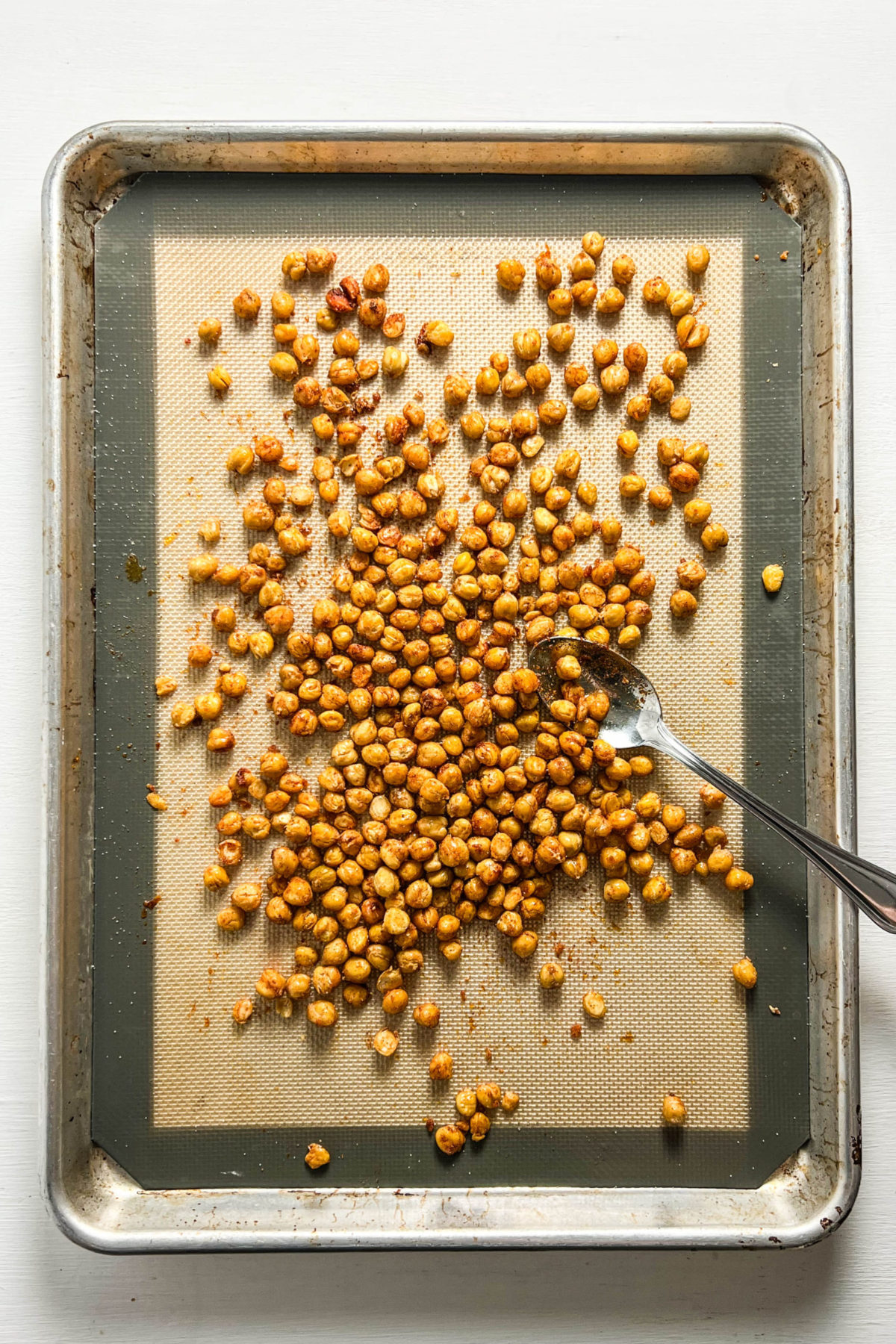 Partially Roasted chickpeas on a baking sheet. 