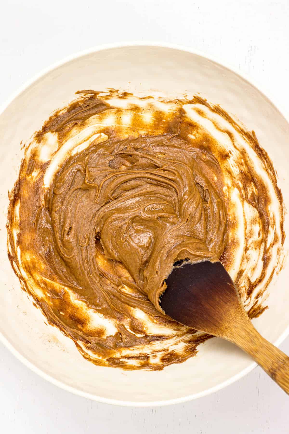 Peanut butter and maple syrup mixed together in a large white bowl.
