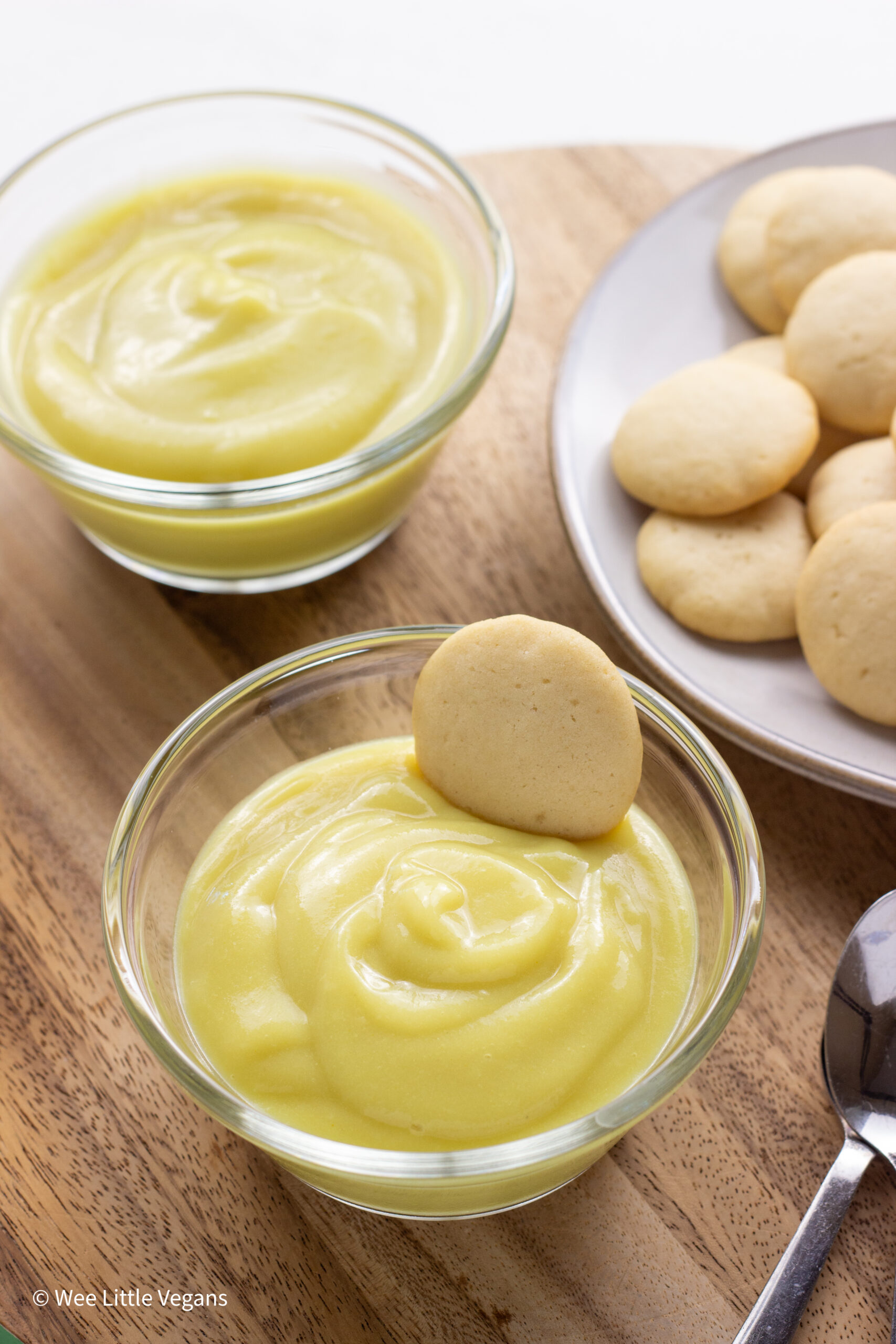 Vegan Banana Flavored Pudding in a small bowl with a cookie resting on the side of bowl.