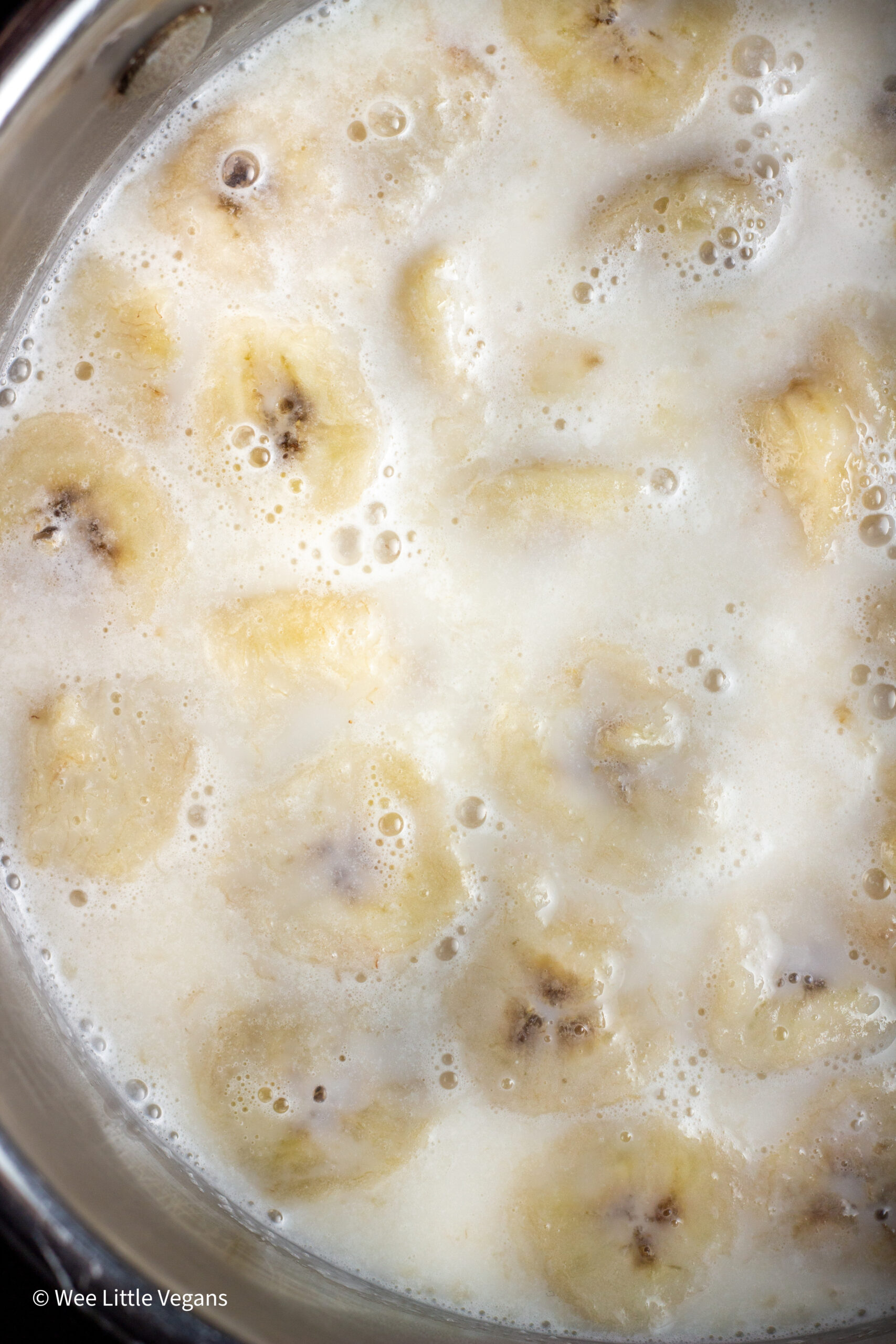 Overhead shot of bananas simmering in non dairy milk.