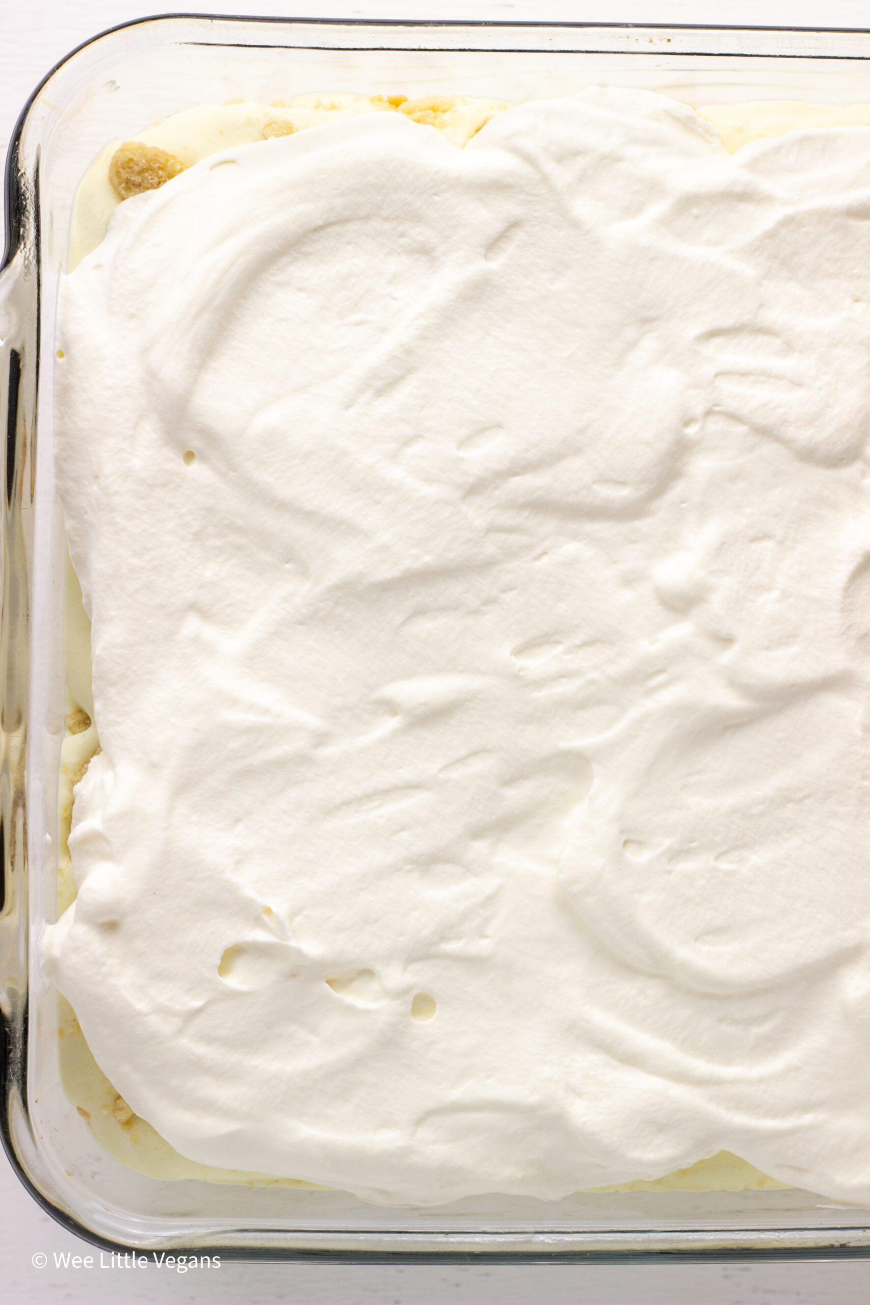 Overhead shot of Vegan Banana Pudding in a casserole dish with whipped topping.