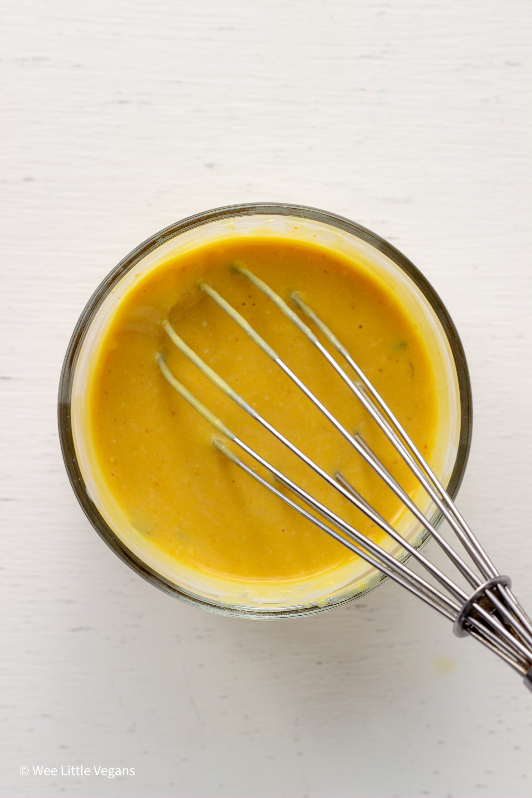 Overhead shot of a small bowl of special sauce with a whisk.