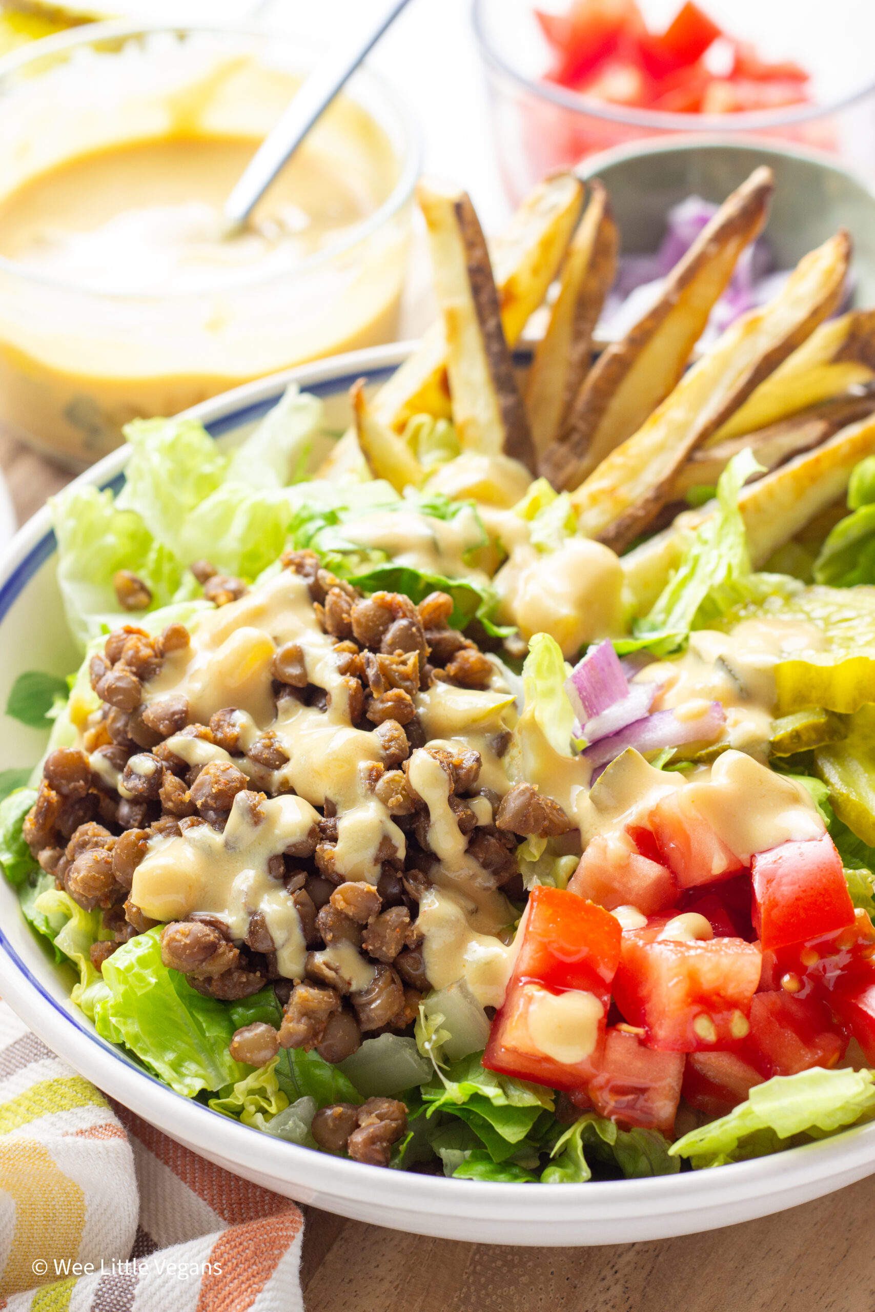 Close up side view of Vegan Burger Bowl with small bowls in the background.