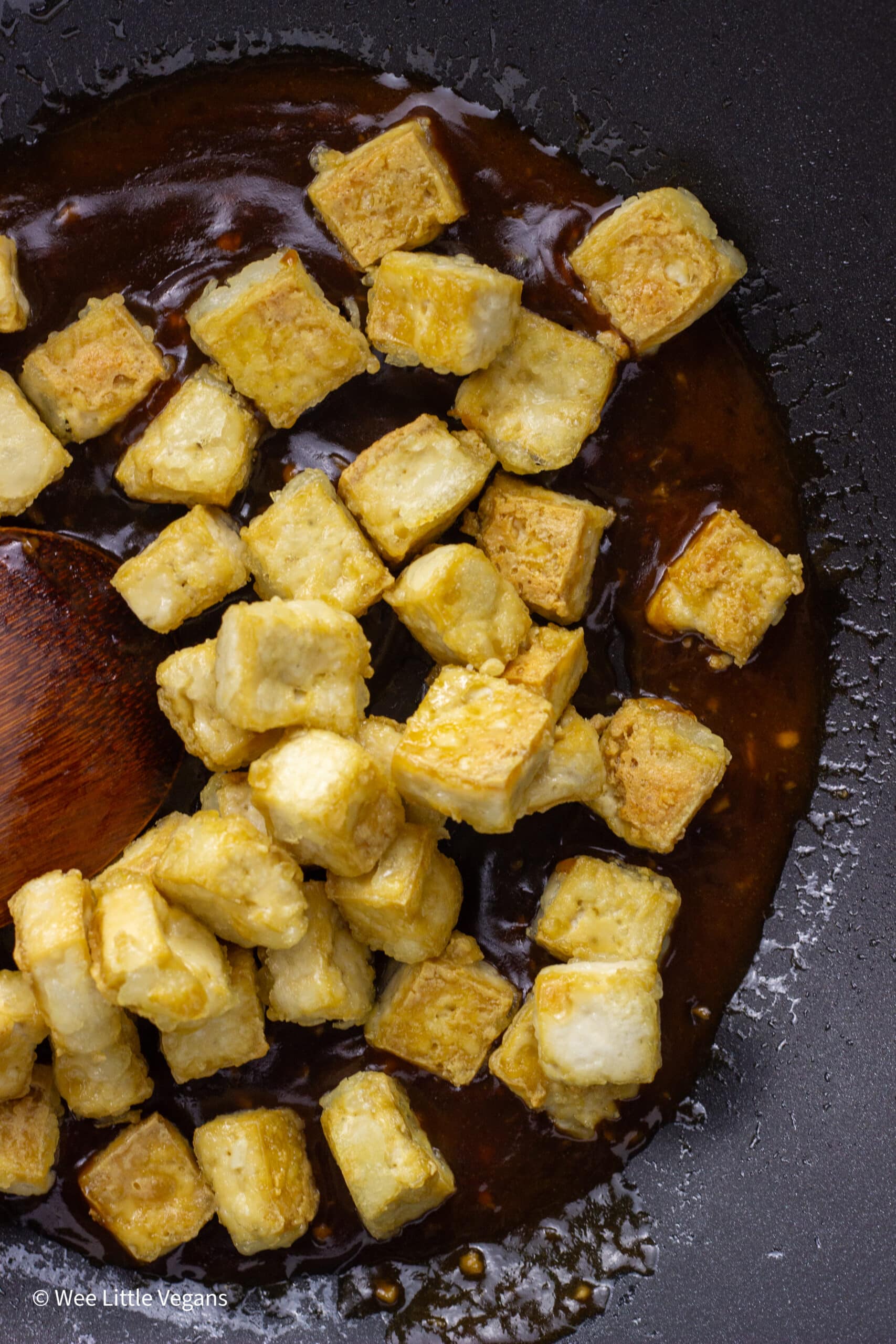 Overhead shot of baked tofu in a pan with sauce.