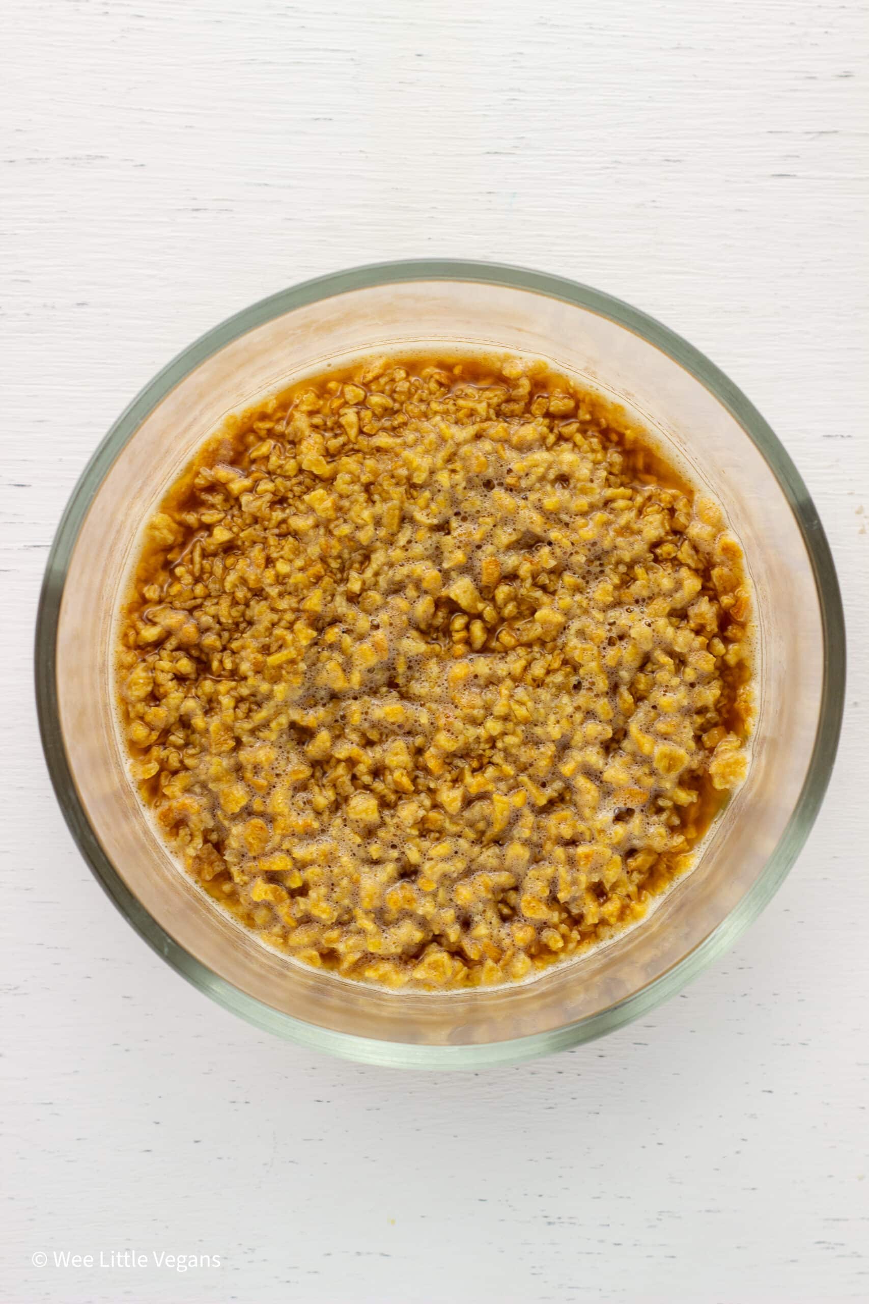 Overhead shot of textured vegetable protein and broth in a bowl.