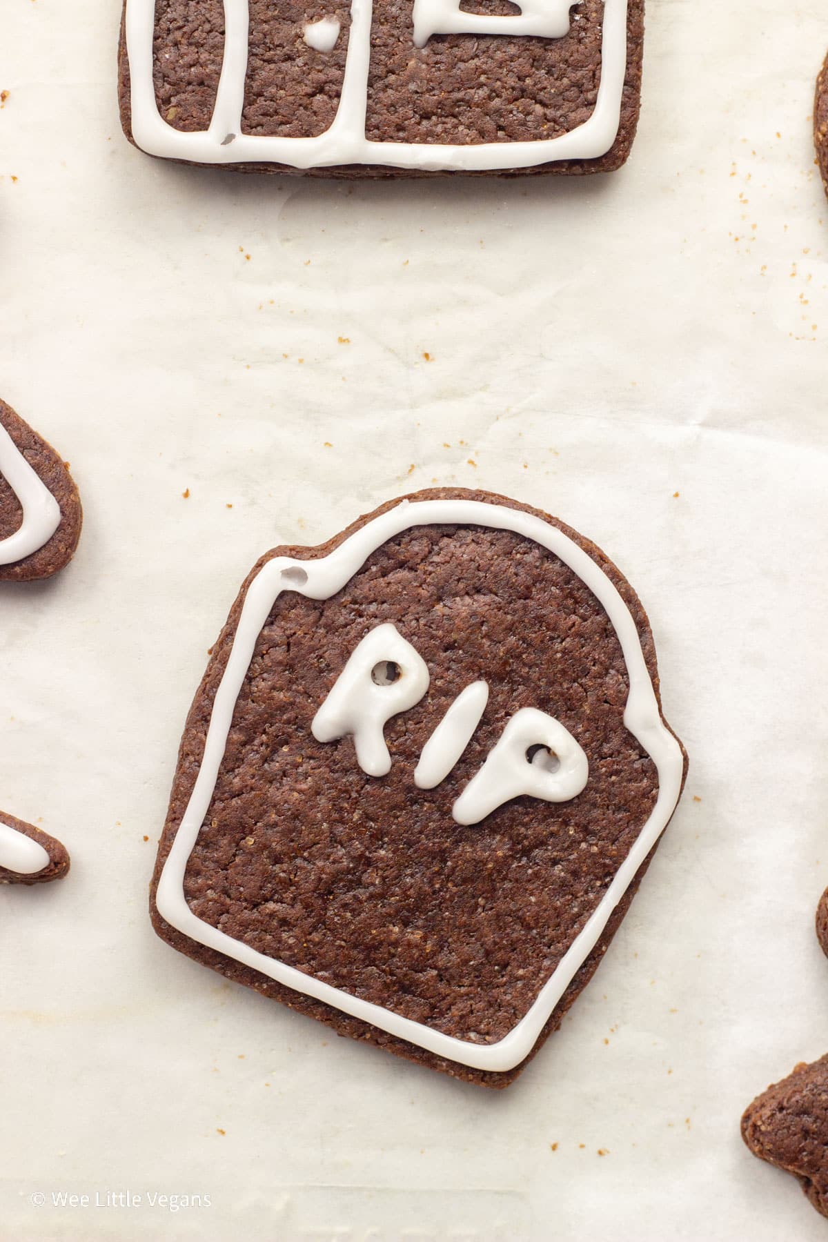 Overhead close up shot of a tombstone shaped Spice Chocolate Cut Out Cookie on parchment paper.