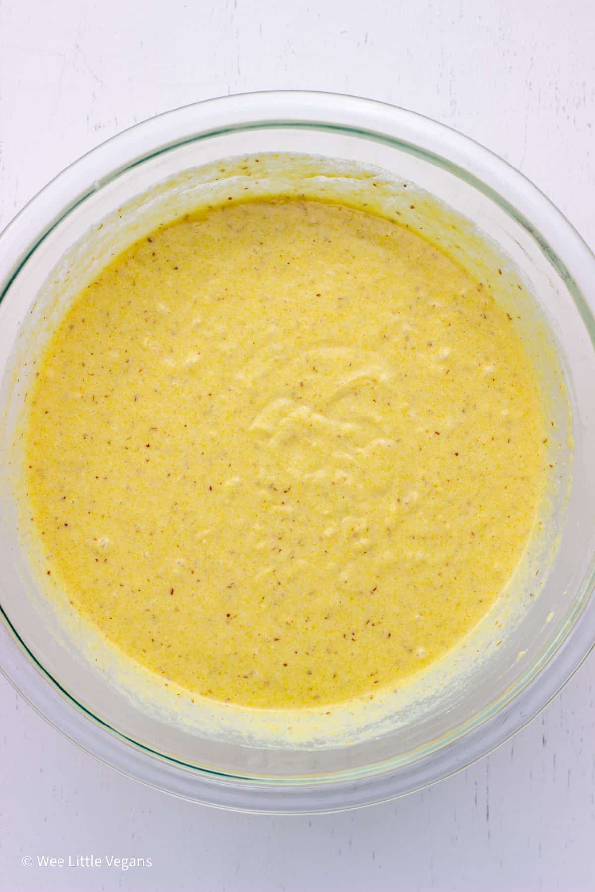 Overhead shot of waffle batter in a glass bowl.