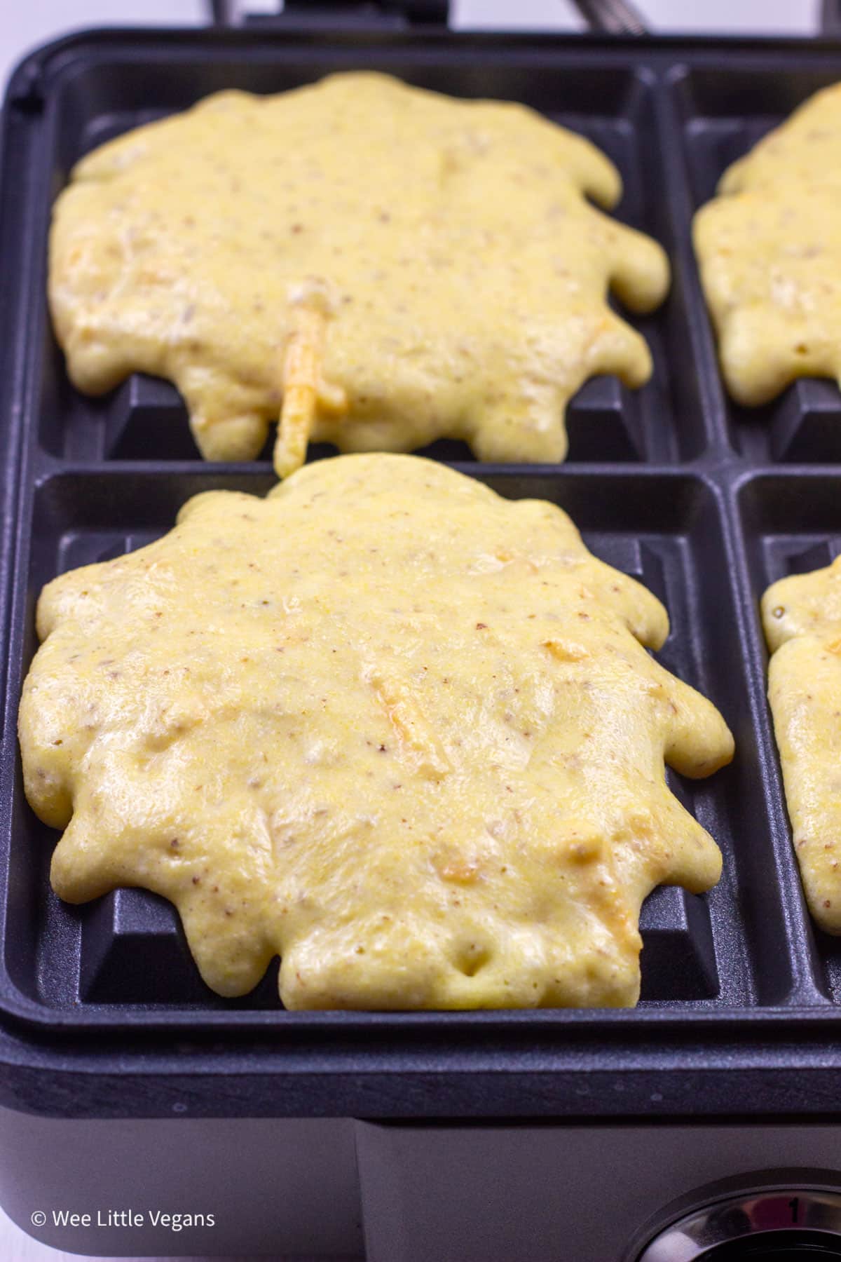 Cornbread Waffle batte in a waffle maker before cooking.