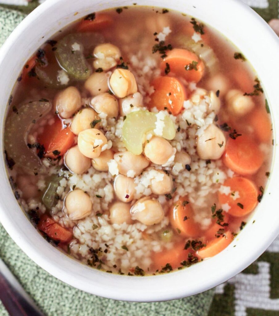 Overhead shot close up shot of Chickpea and Stars Soup in a white bowl.