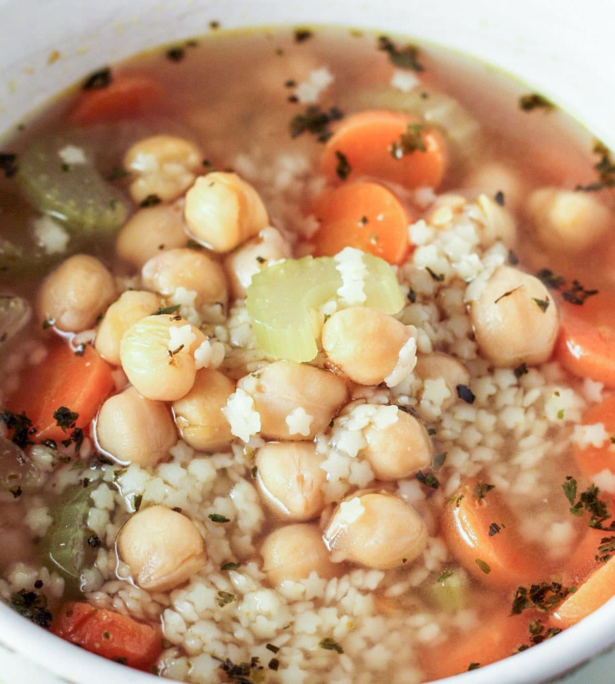 Extreme close up of Chickpea and Stars Soup in a bowl.