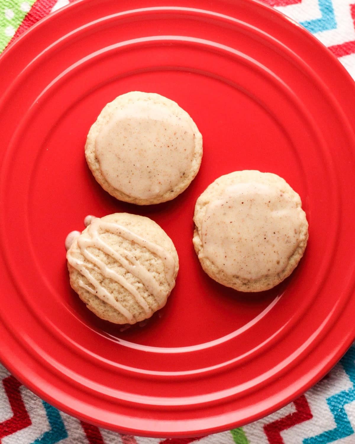 Overhead view of three Eggnog Spiced Cookies on a red plate.