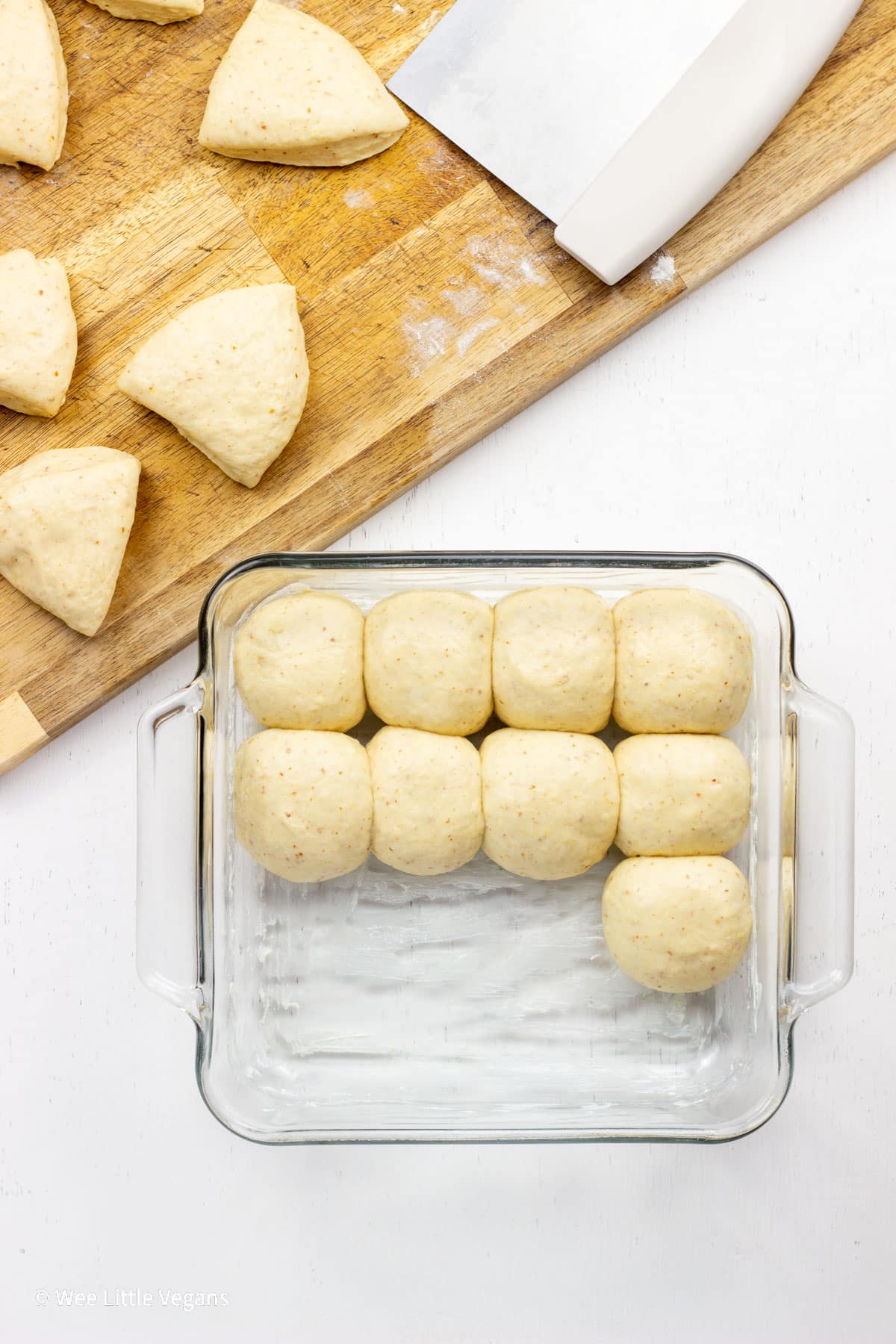 Overhead shot of rolls shaped in a baking dish before baking.