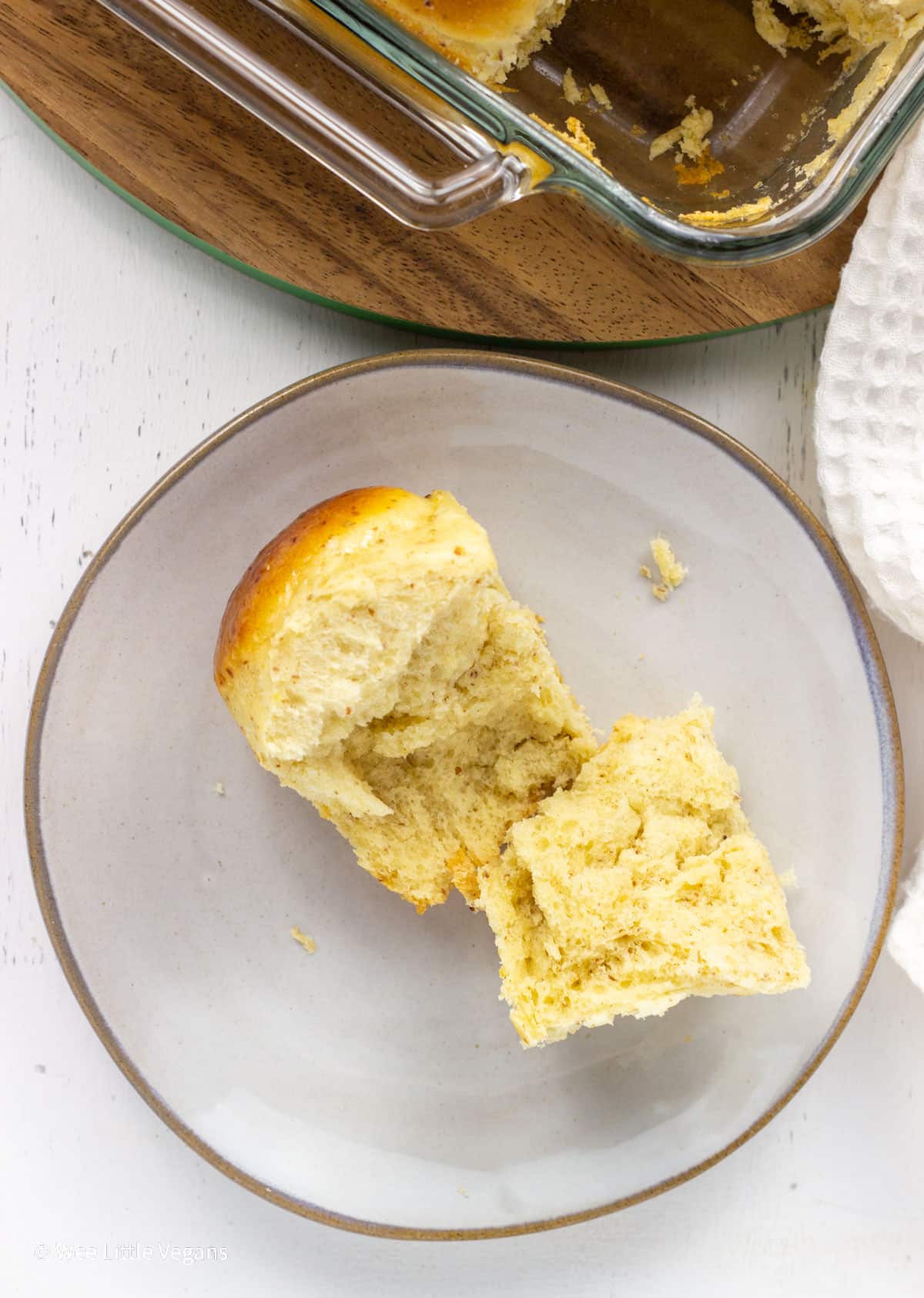 Close up overhead view of a Vegan Hawaiian Roll on a small plate. The roll has been pulled apart to show the interior.