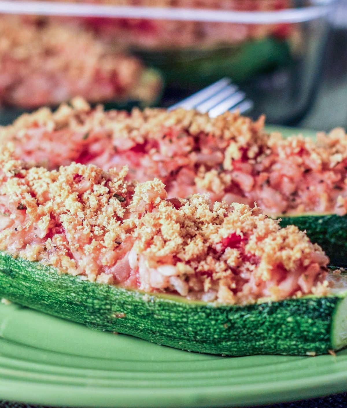 Close up side view of Vegan Stuffed Zucchini on a small green plate.