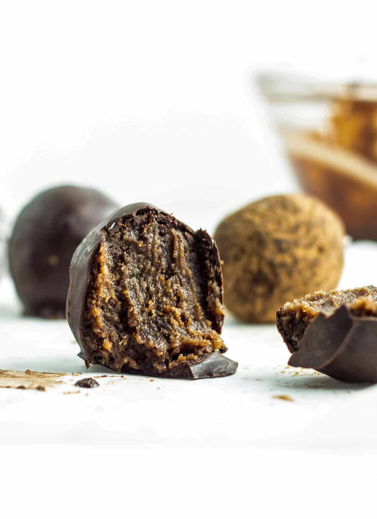 Interior of Chocolate Coconut Butter Truffle. There are whole truffles in the background.