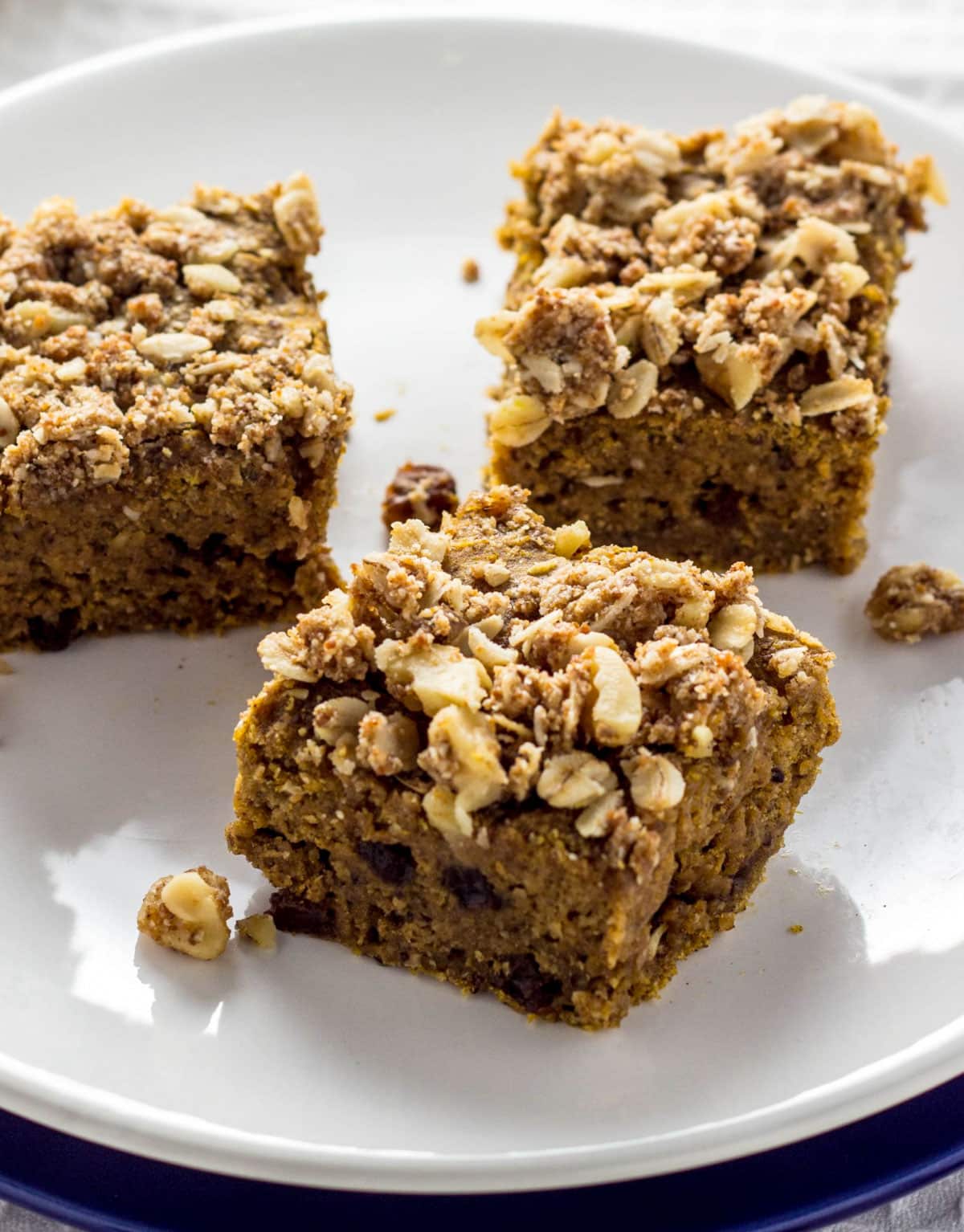 Close up view of three Cinnamon Raisin Butternut Squash Squares on a small white plate.
