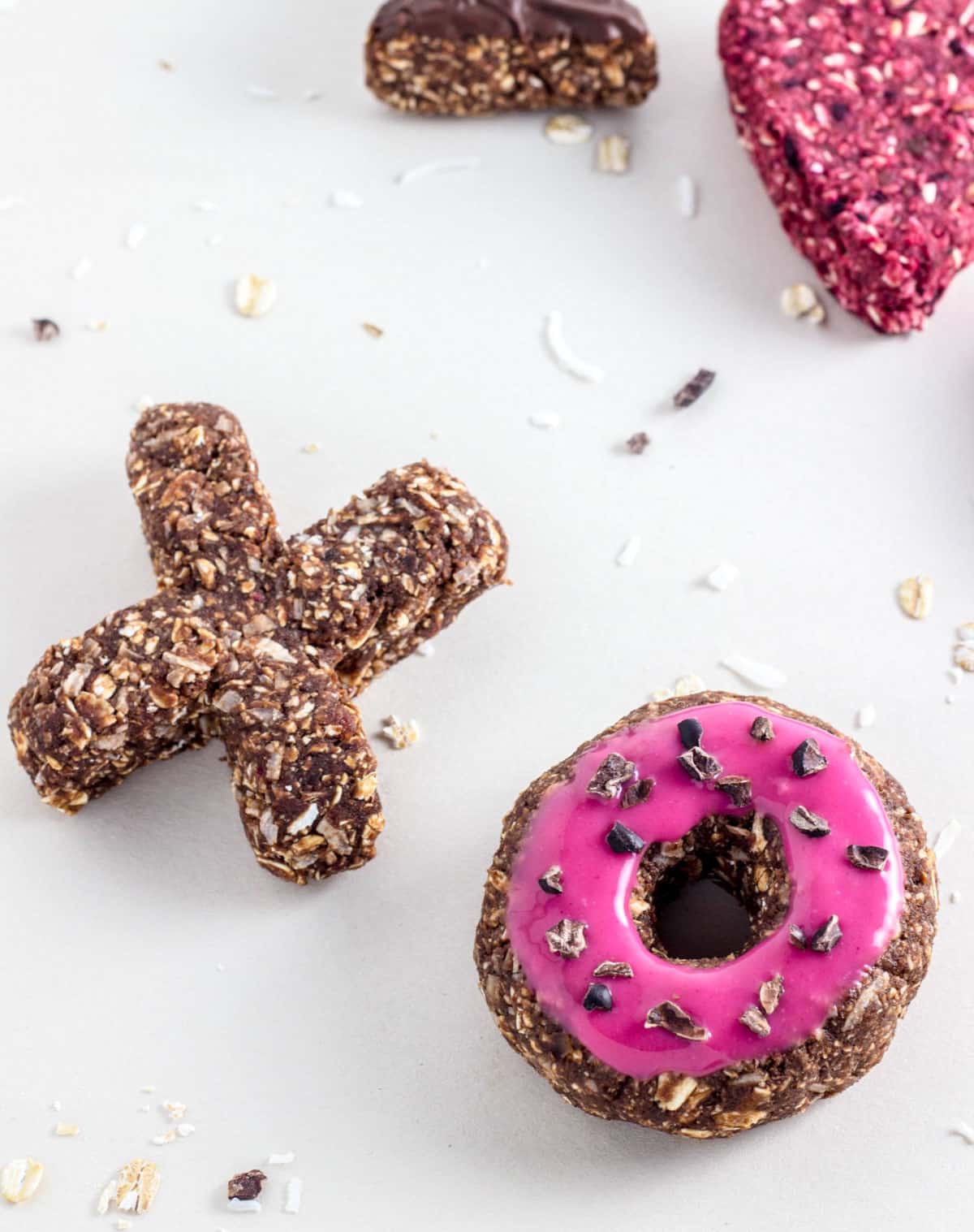 Two Vegan Raw Doughnuts on a white background. One doughnut is an X and the other is an O.