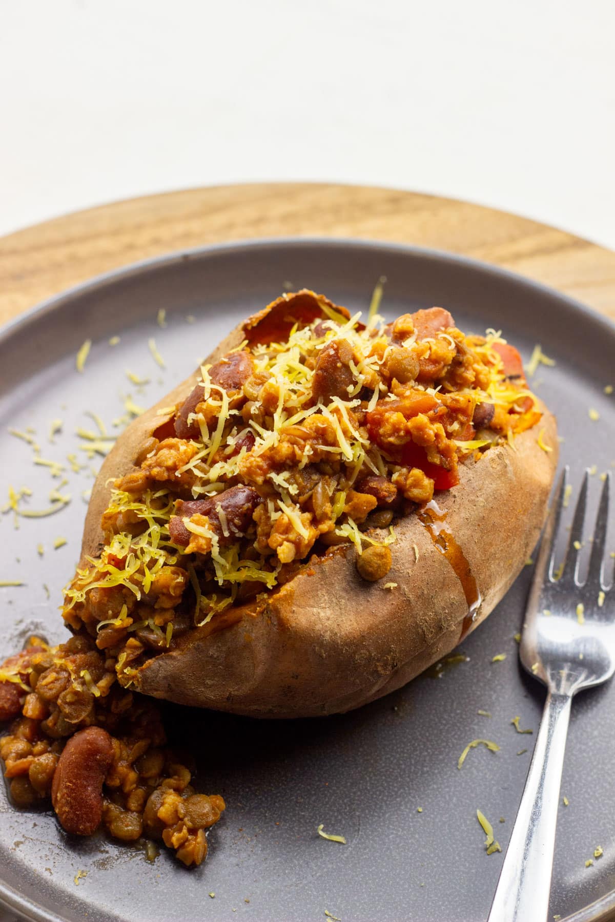 A TVP Chili Stuffed Sweet Potato on a grey plate. TVP is textured vegetable protein that is made from soy.