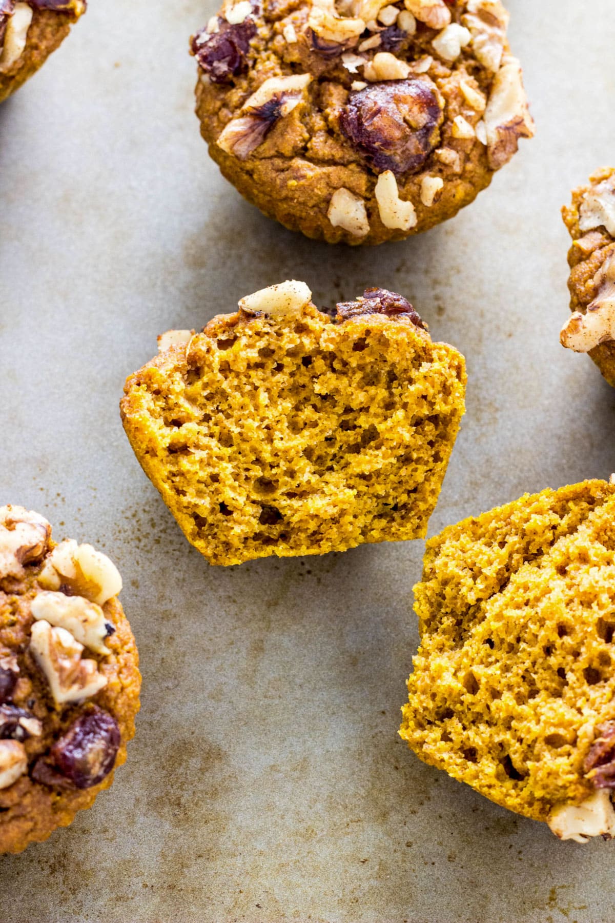 Close up of the inside of a Date & Nut Pumpkin Muffin. There are more muffins in the background.