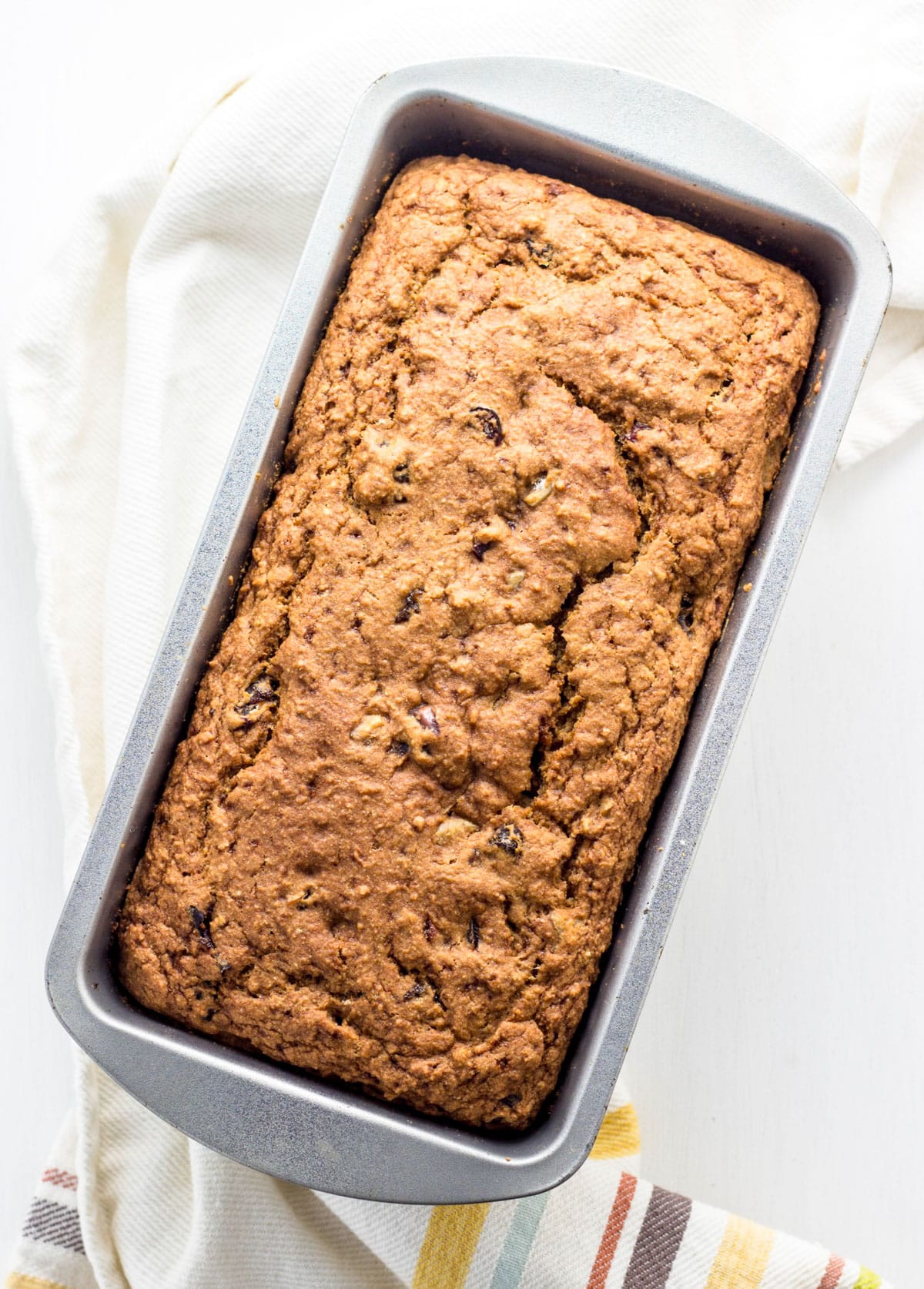 Overhead view of a loaf of Fruit & Nut Breakfast Quick Bread in a metal loaf pan.