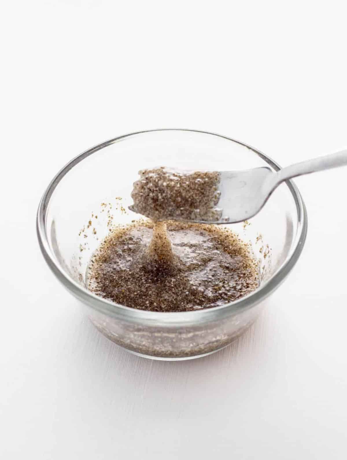 A small bowl of chia egg lifted by a fork. Image is part of How to Make Flax and Chia Eggs guide.