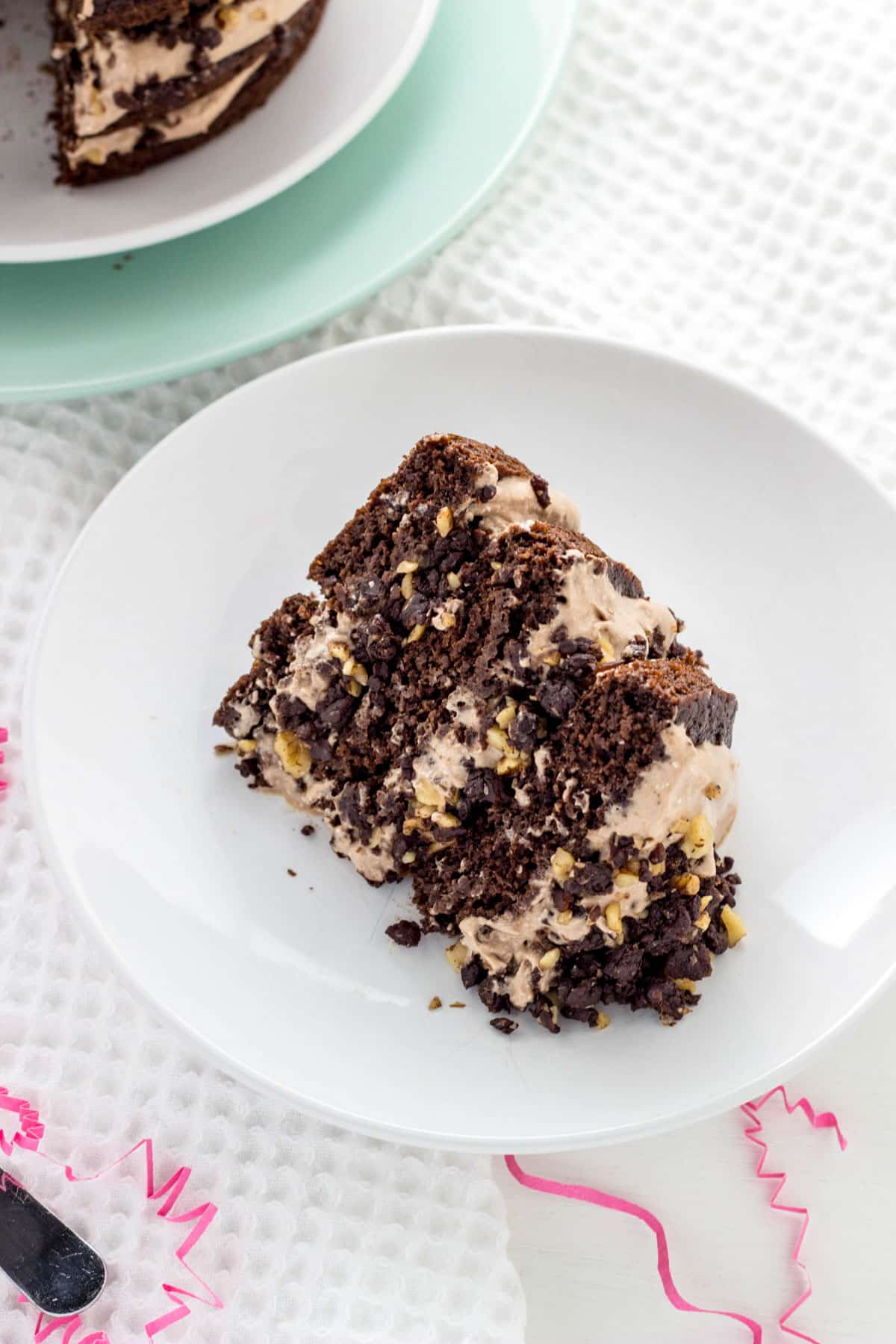 A slice of Vegan Chocolate Brownie cake on a small white plate.