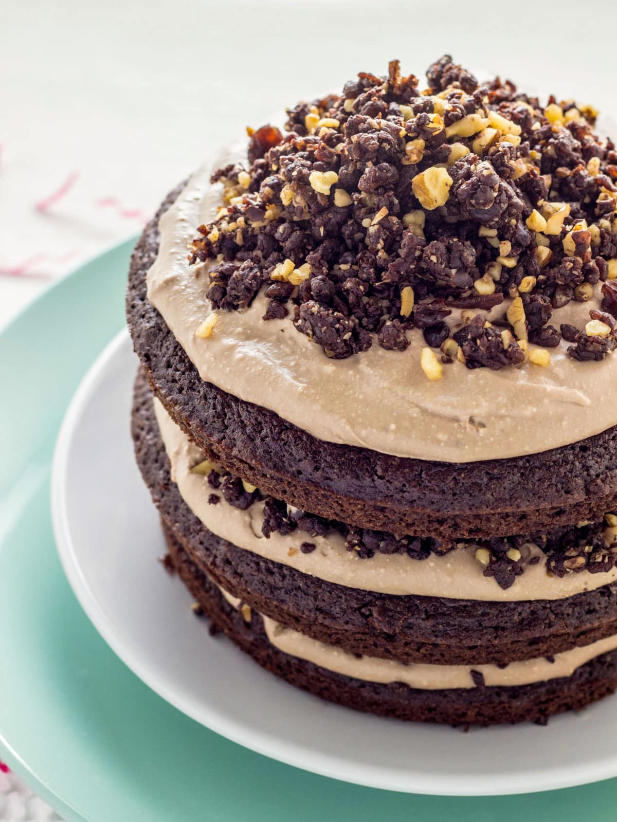 Side view of Vegan Chocolate Brownie Cake. Layers of chocolate cake with chocolate whipped cream and raw brownie crumble.