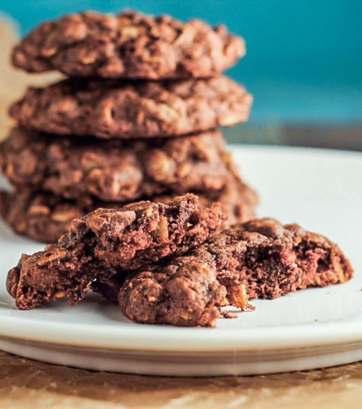 Vegan Chocolate Oatmeal Cookie showing the interior of the cookie. There is a stack of cookies behind the main cookie.