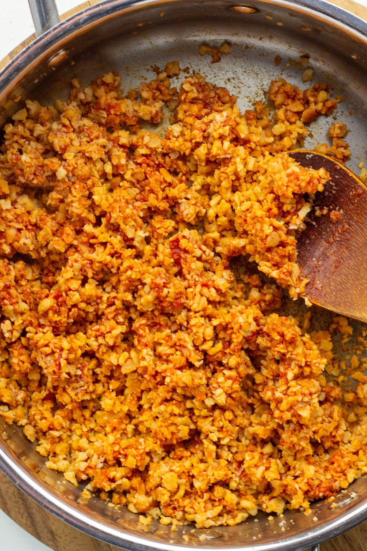 Overhead view of a skillet of textured vegetable protein with tomato paste and taco seasoning.