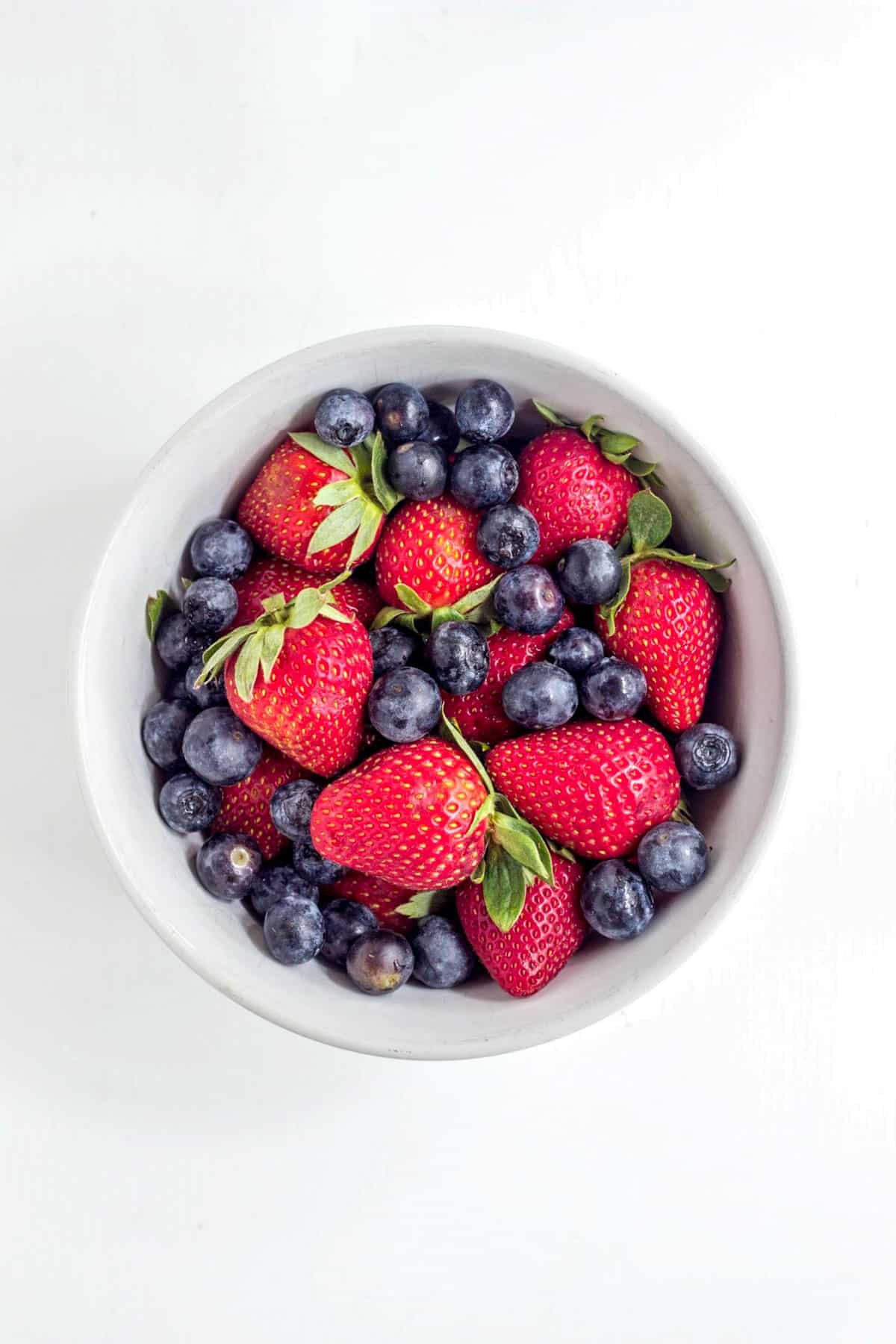 A bowl of strawberries and blueberries.