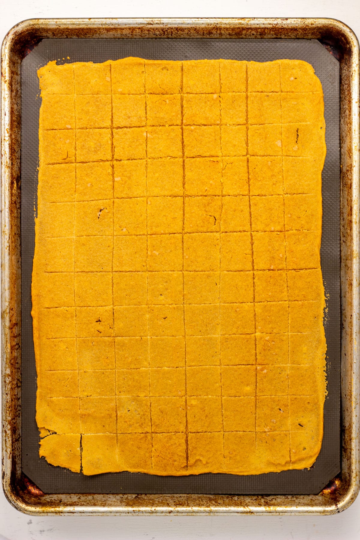 Overhead view of partially baked lentil crackers on a baking sheet.