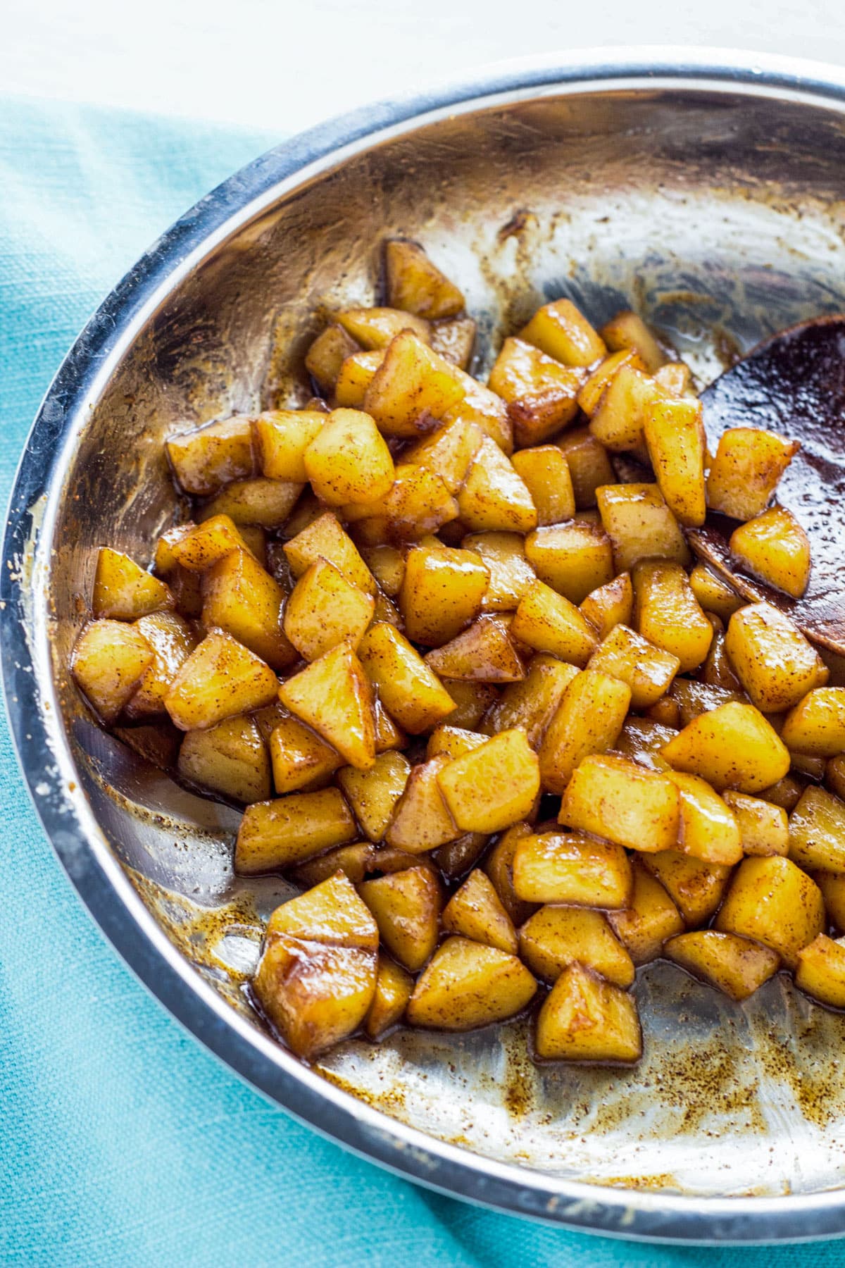 A sauté pan of apple pieces that have been cooked with cinnamon and coconut sugar.