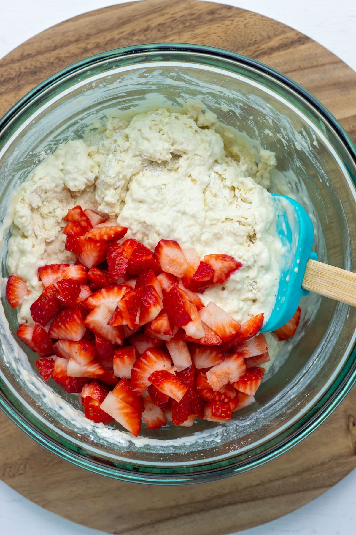Overhead view of biscuit dough and chopped strawberry.