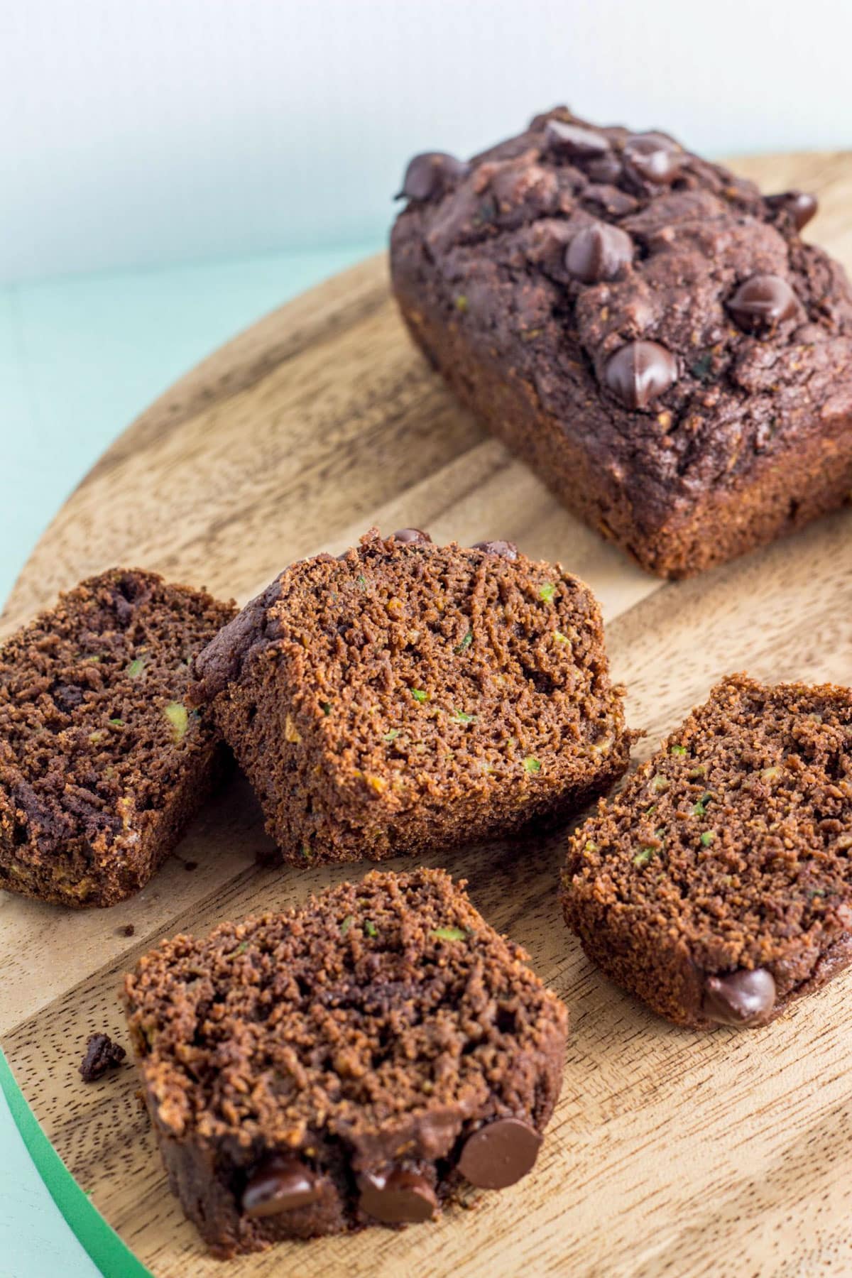 Slices on Chocolate Zucchini Bread on a wooden board.