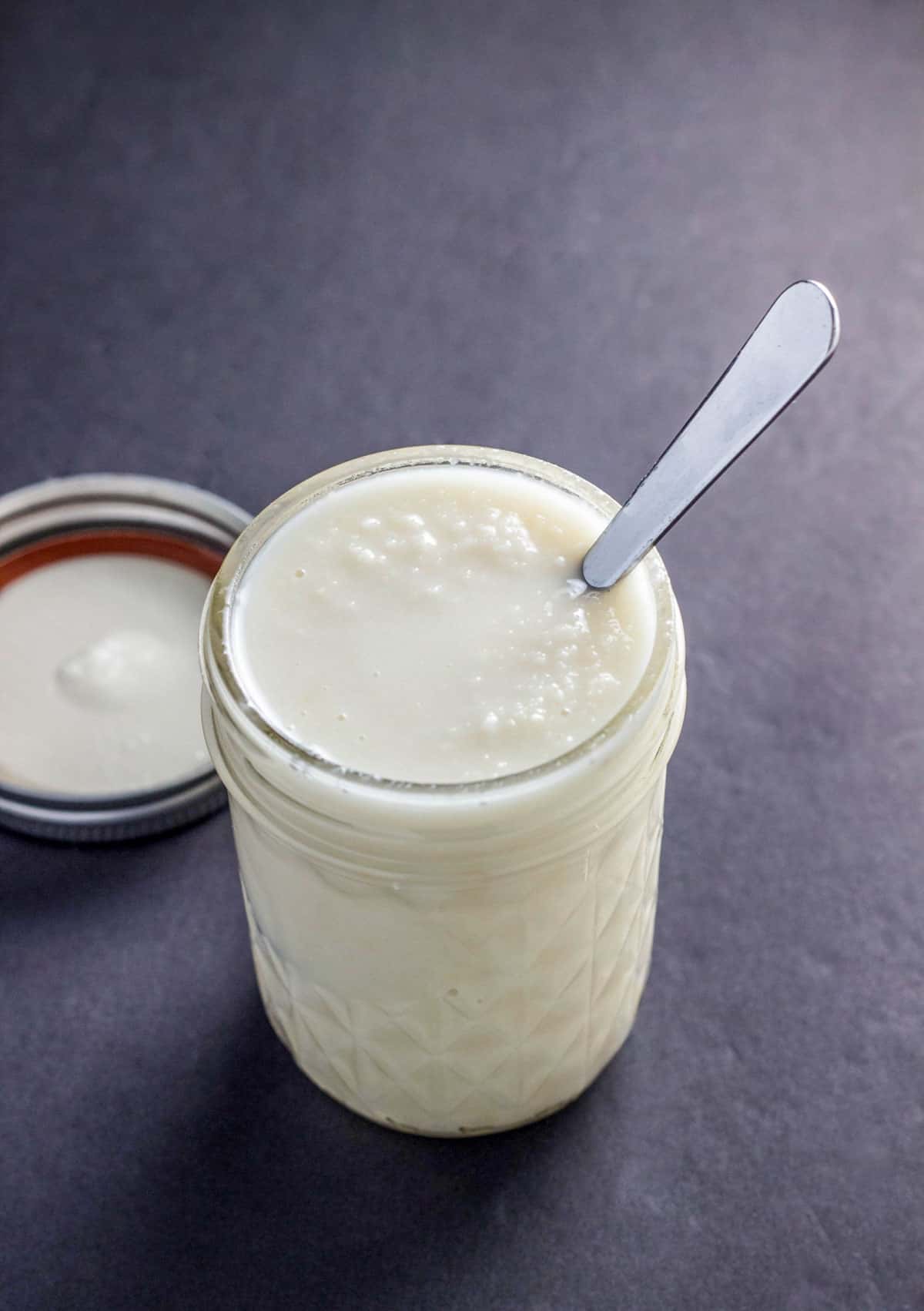 A jar of coconut butter with a spoon in it.