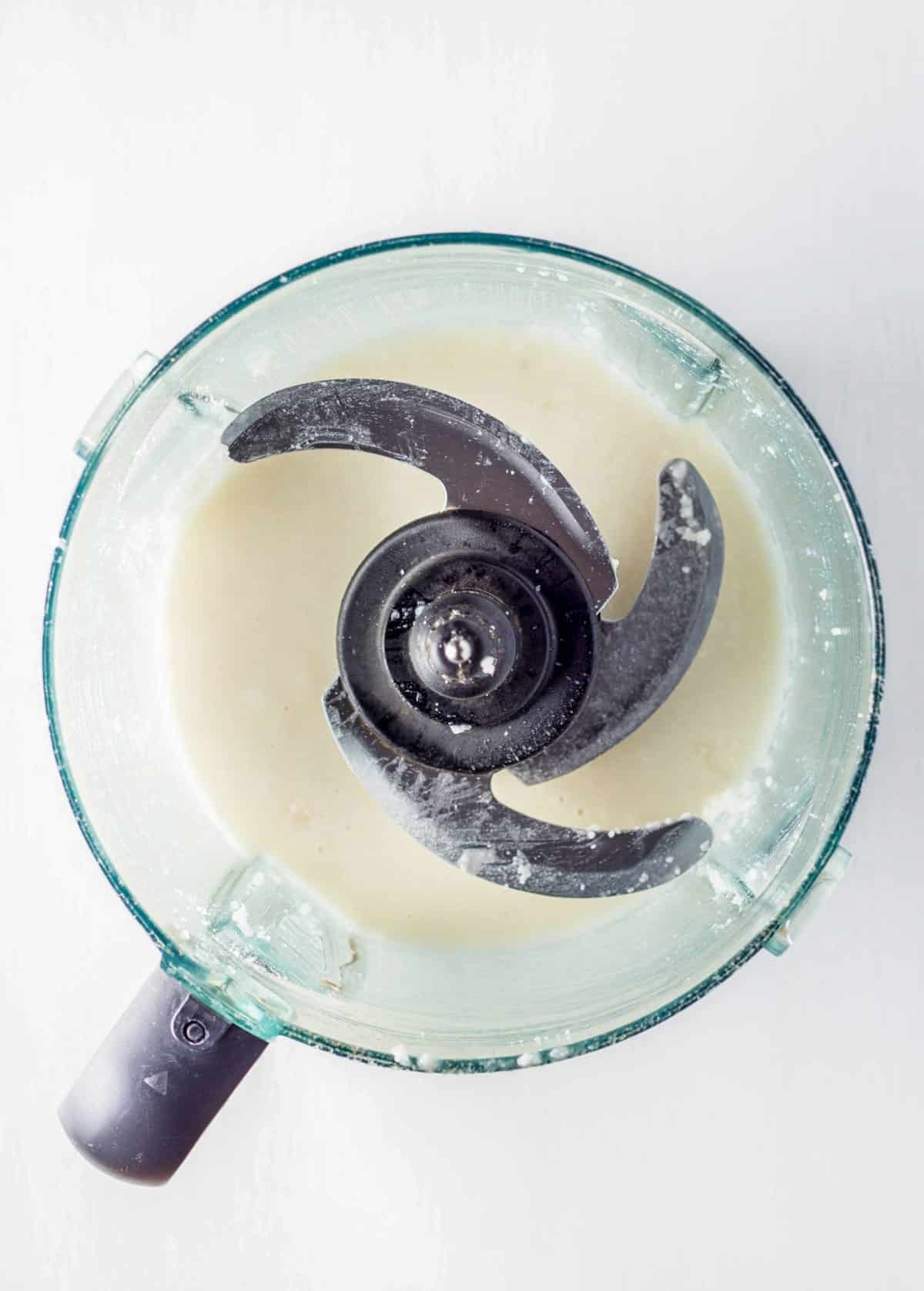 Coconut butter in the bowl of a food processor.