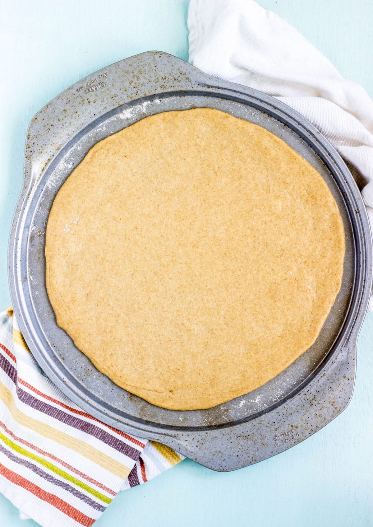 Whole Wheat Yeast Free Pizza Crust dough rolled out on a round baking pan.