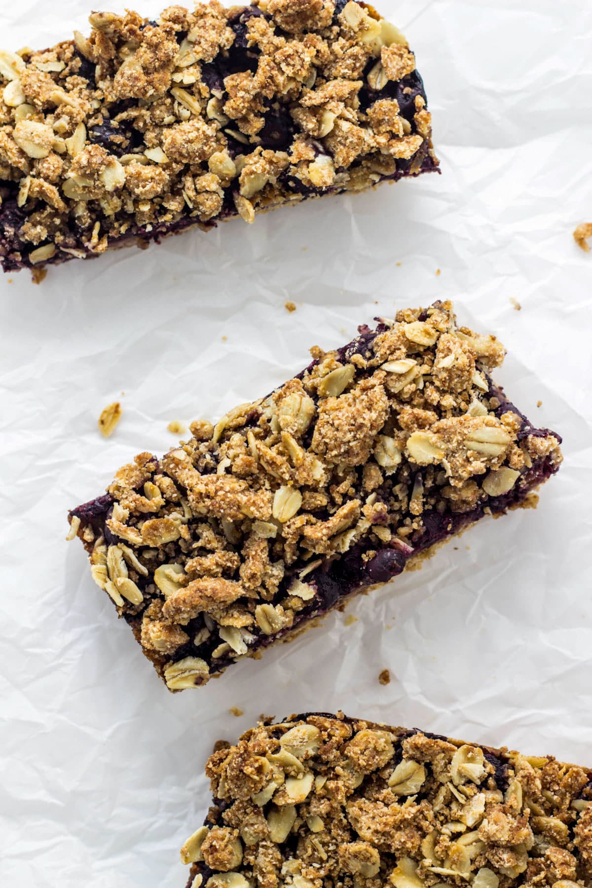 Blueberry Oatmeal Crumb Bars on crumbled parchment paper.