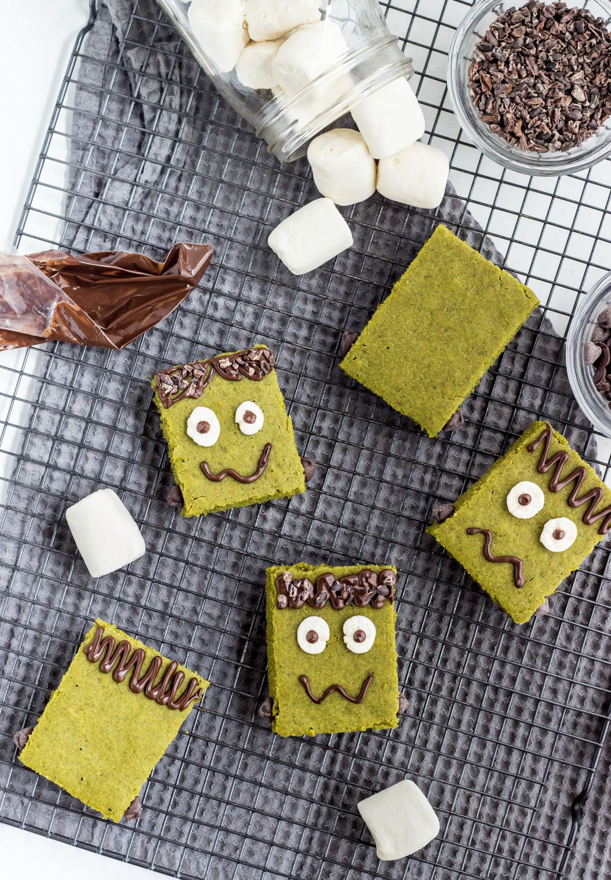 Overhead shot of decorated Frankenstein Vegan Snack Cakes on a cooling rack.