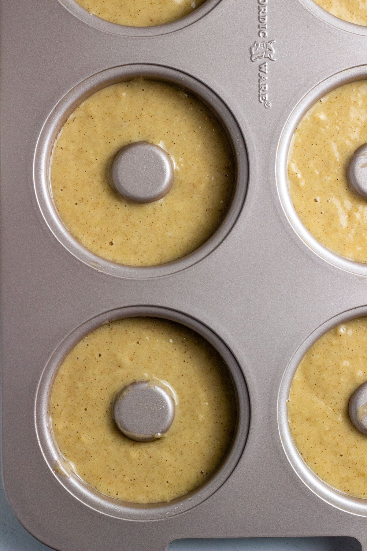 Close up of a doughnut pan filled with batter.