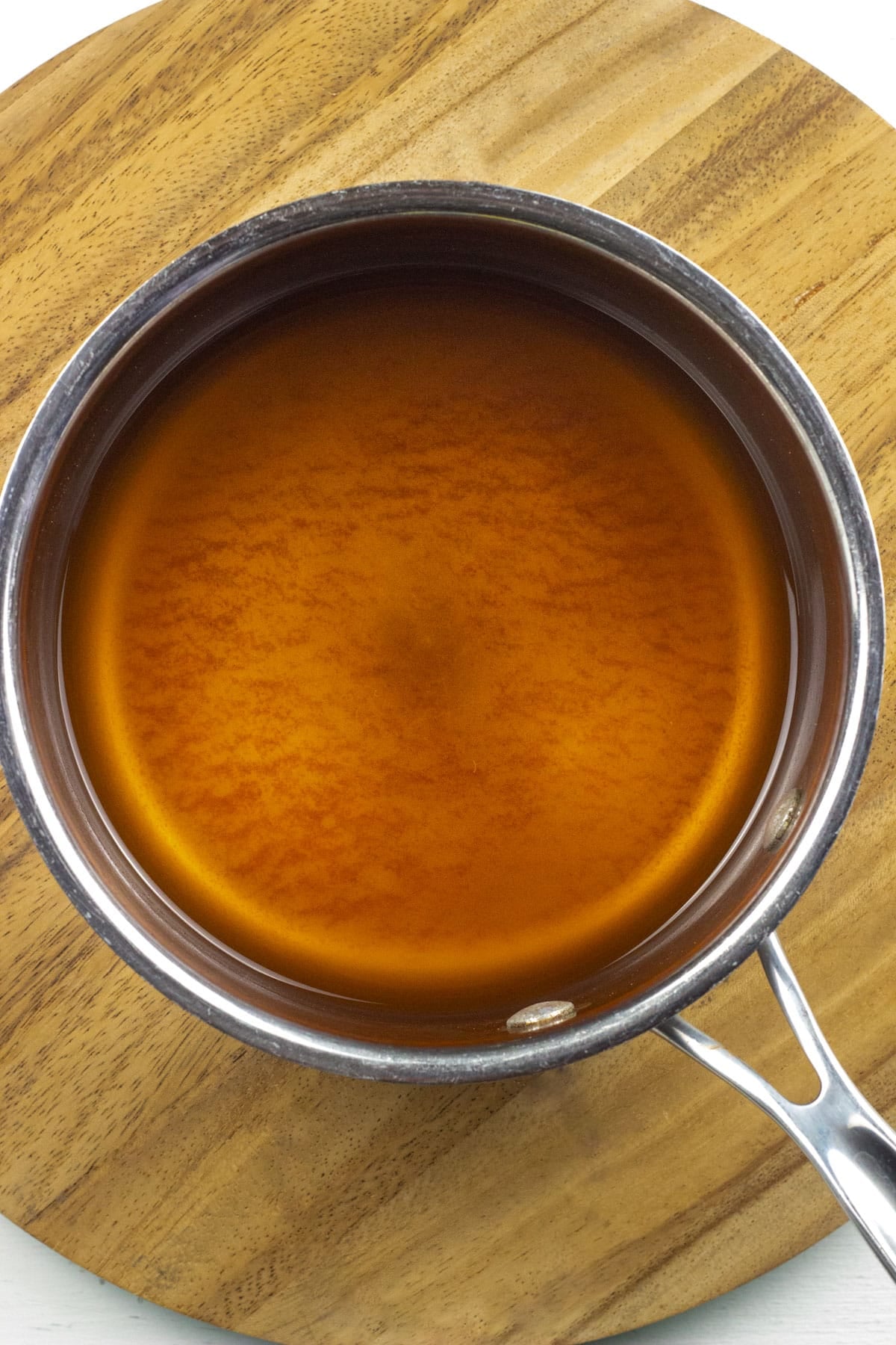 A sauce pan with apple cider that has been reduced down.