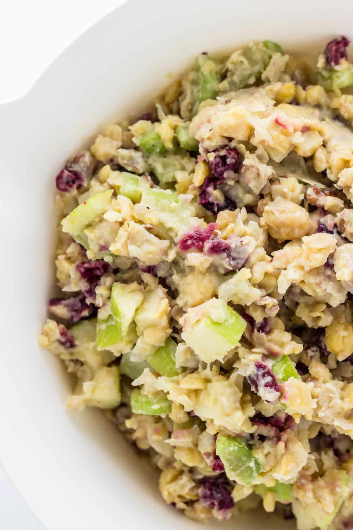 Close up of Vegan Cranberry Chickpea Salad mixture in a white bowl.