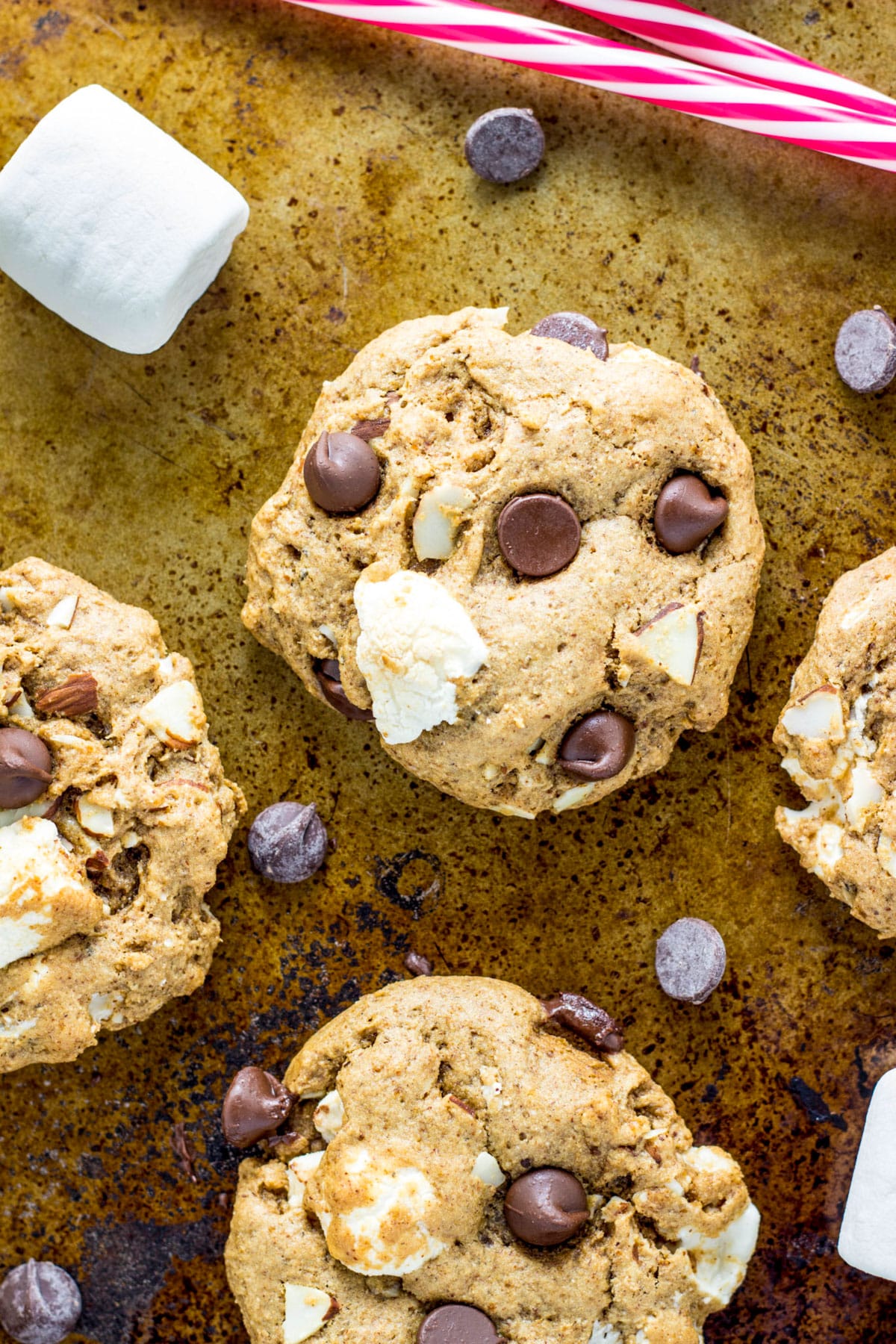 Close up of Vegan Rocky Road Cookies on a baking sheet with chocolate chips and marshmallows.