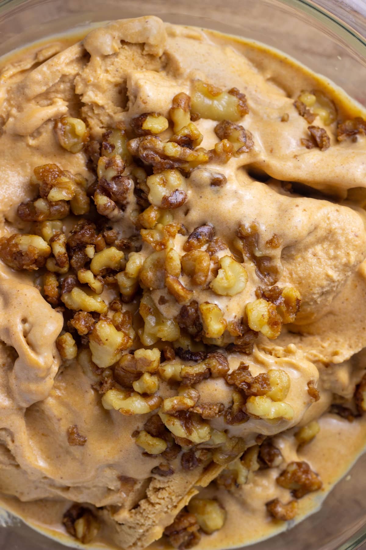 Close up of a large bowl of Vegan Pumpkin Ice cream with candied walnuts on top.